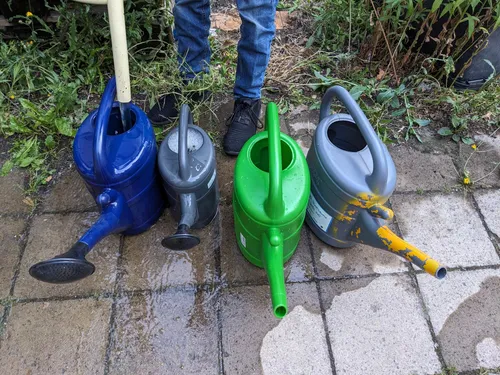 Vier Gießkannen stehen bereit zum Auffüllen