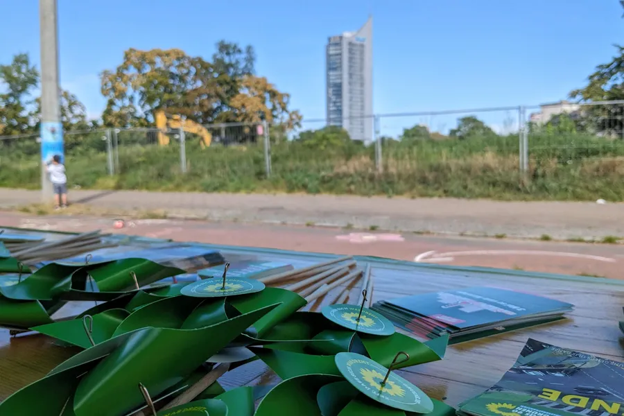 Grüne Spielzeug-Windmühlen vor dem City-Hochhaus